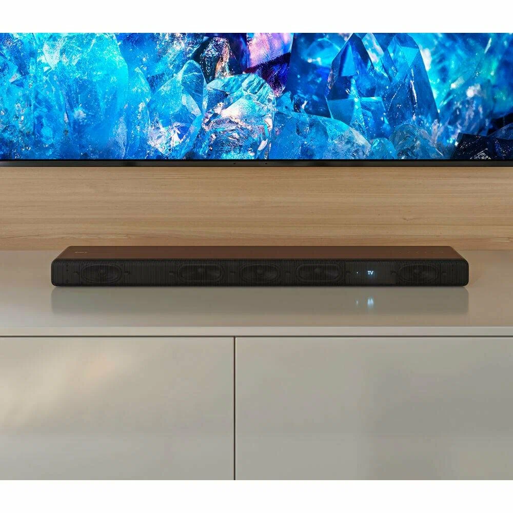 Sony HT-A3000 с текстурированной передней панелью под телевизором на полке